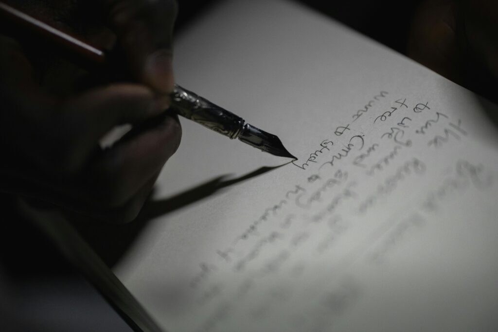 A close-up shot of a hand writing with a fountain pen, capturing the elegance of ink on paper.